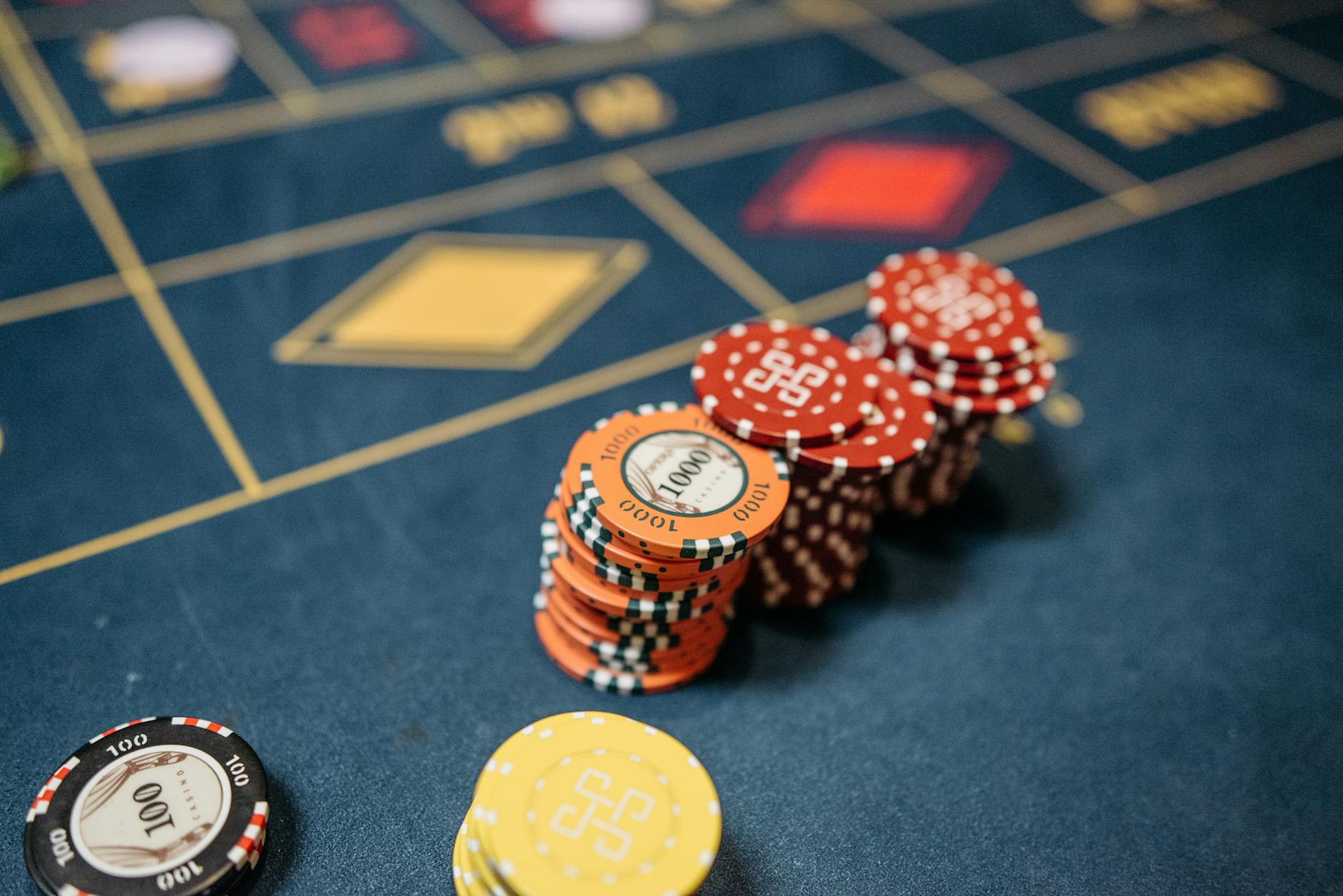 Stacked casino chips on a vibrant roulette table, symbolizing chance and gaming excitement.